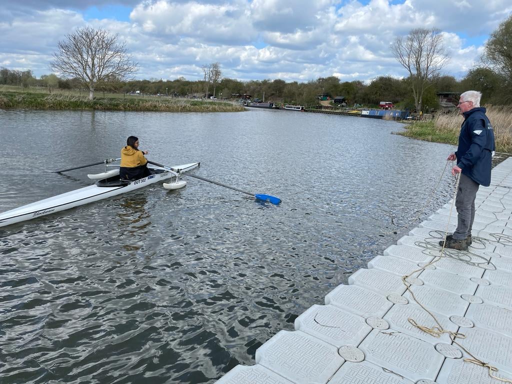 Student rowing with coach supervision